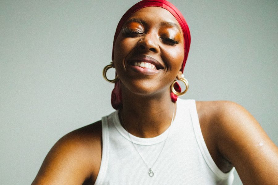 Photo of Onai wearing a white vest and colourful headband