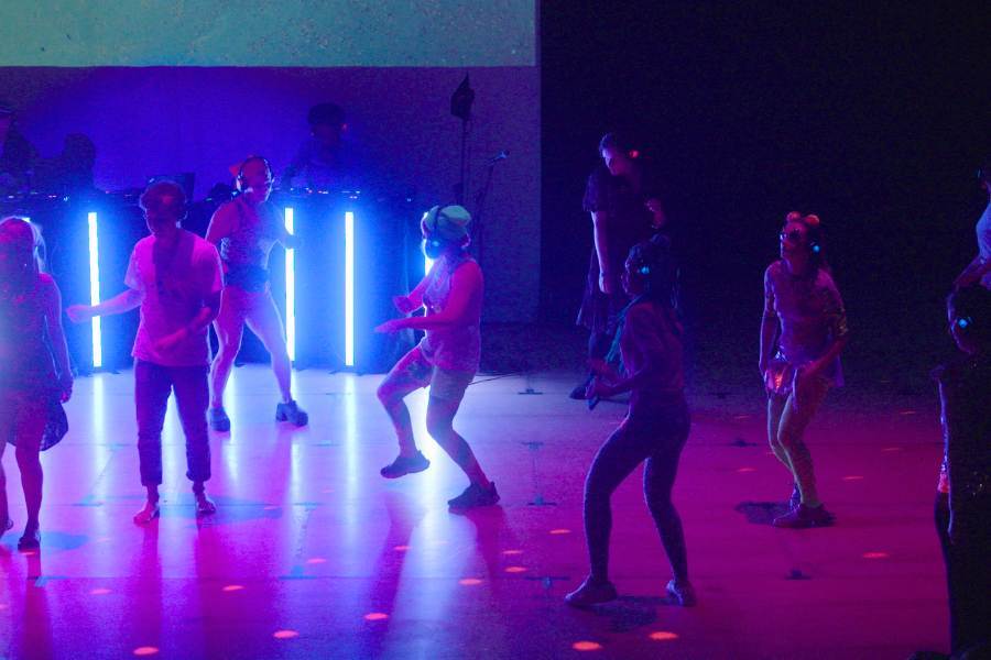 People dance in a silent disco with neon lighting
