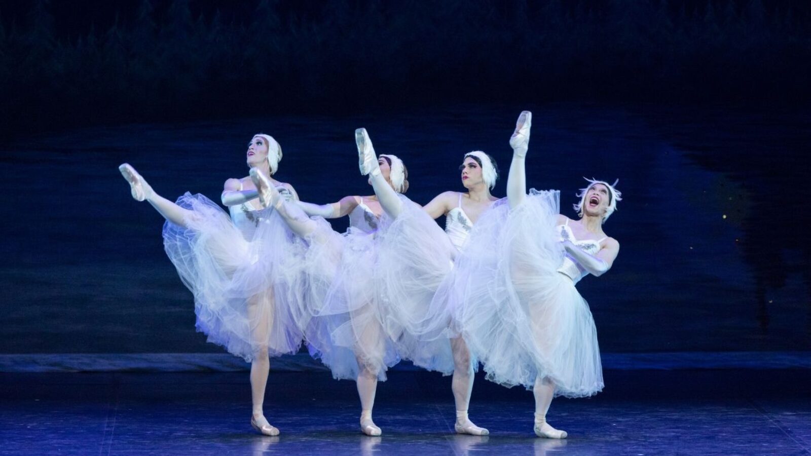 Four male ballerinas dance to Swan Lake