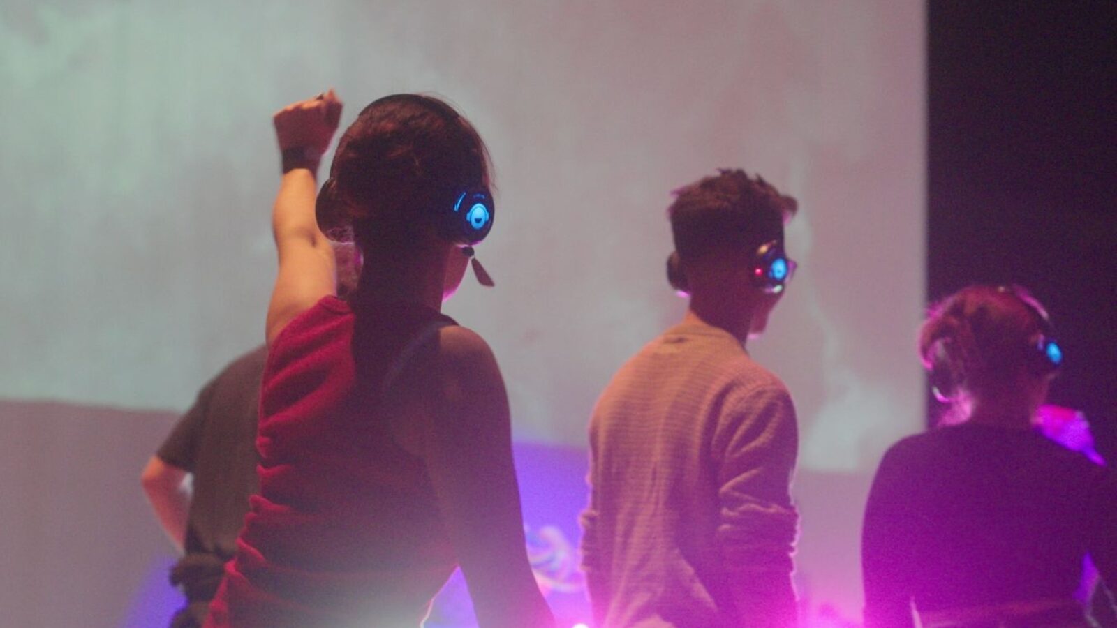 People dance at a club night with headphones