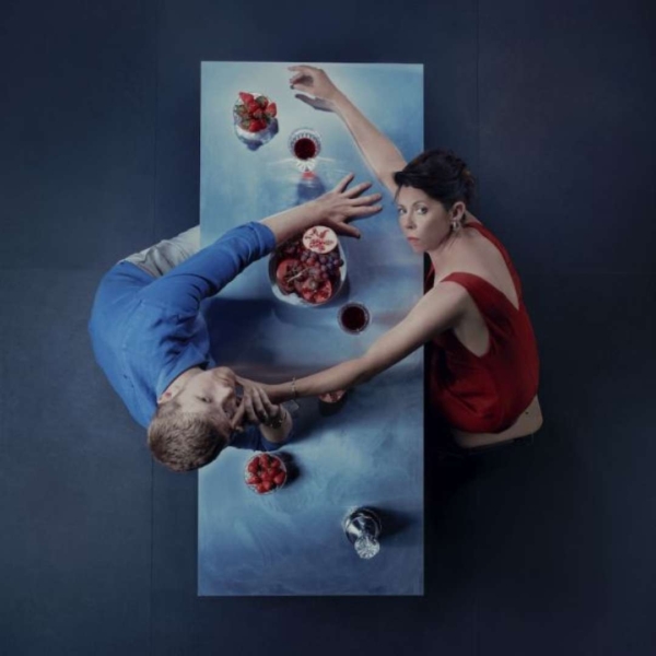 An aerial image over a table where two people look up with bowls of fruit around them