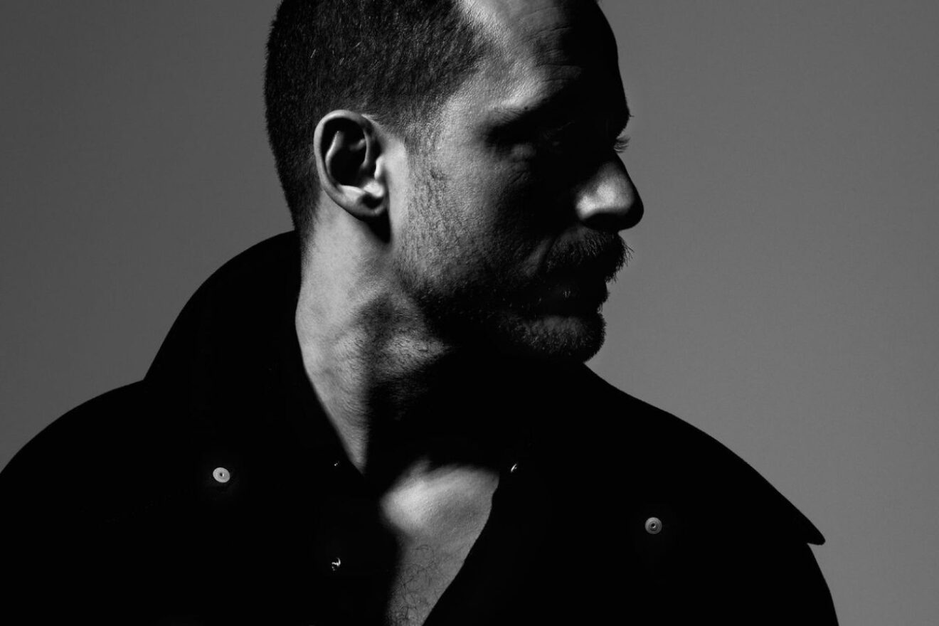 Black and white Image of a man from shoulders to head, looking off to the side.