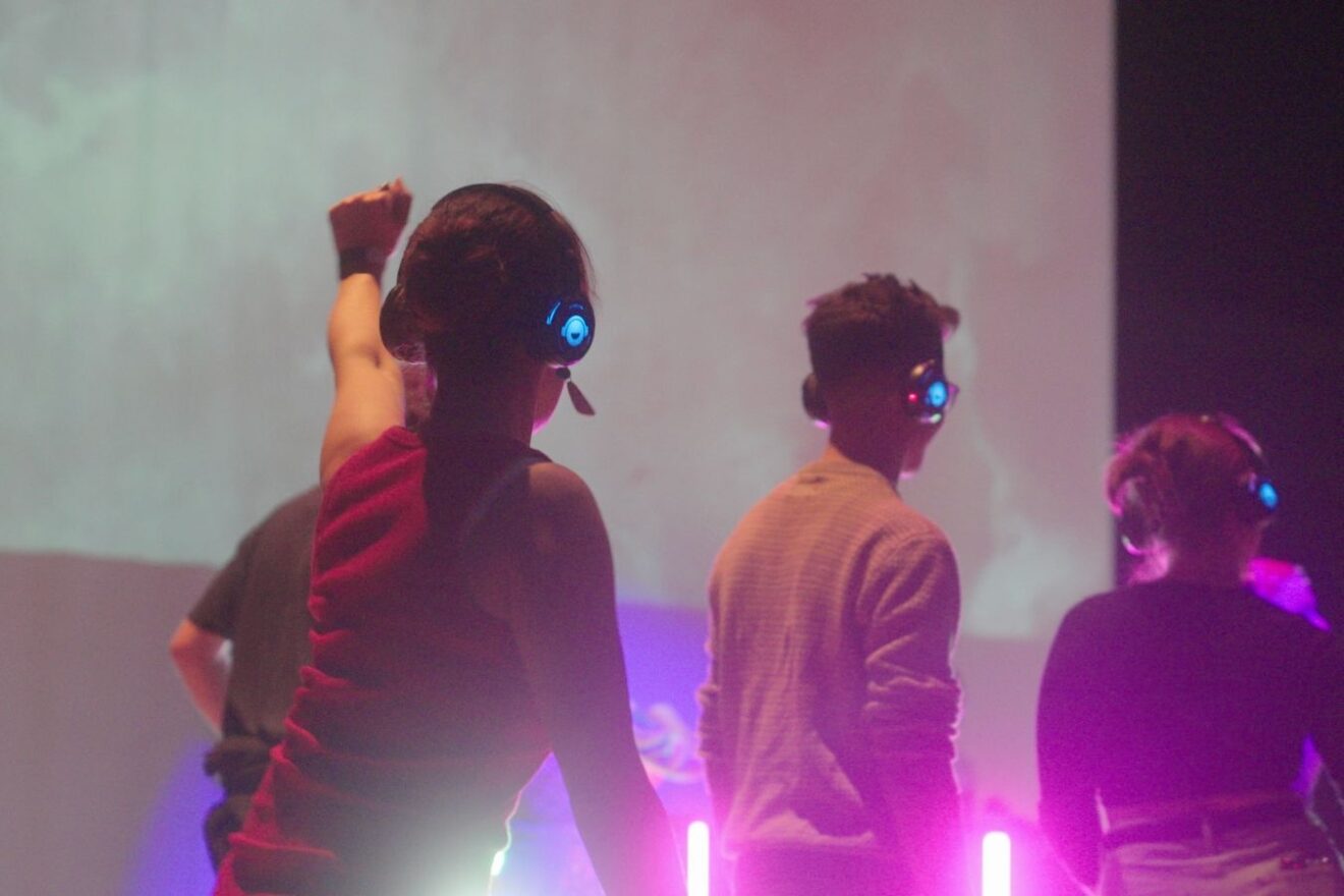 People dance at a club night with headphones
