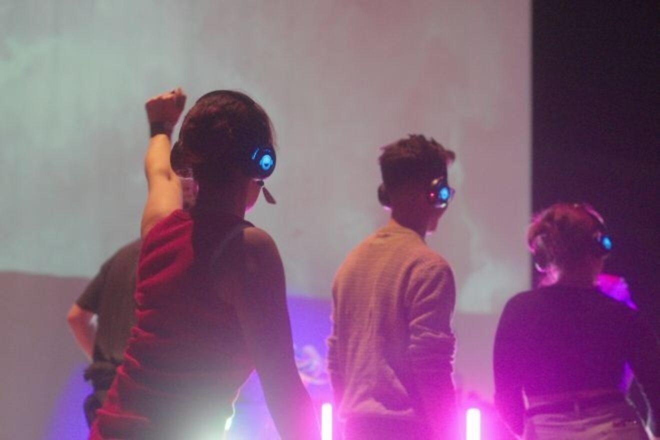 People dance at a club night with headphones